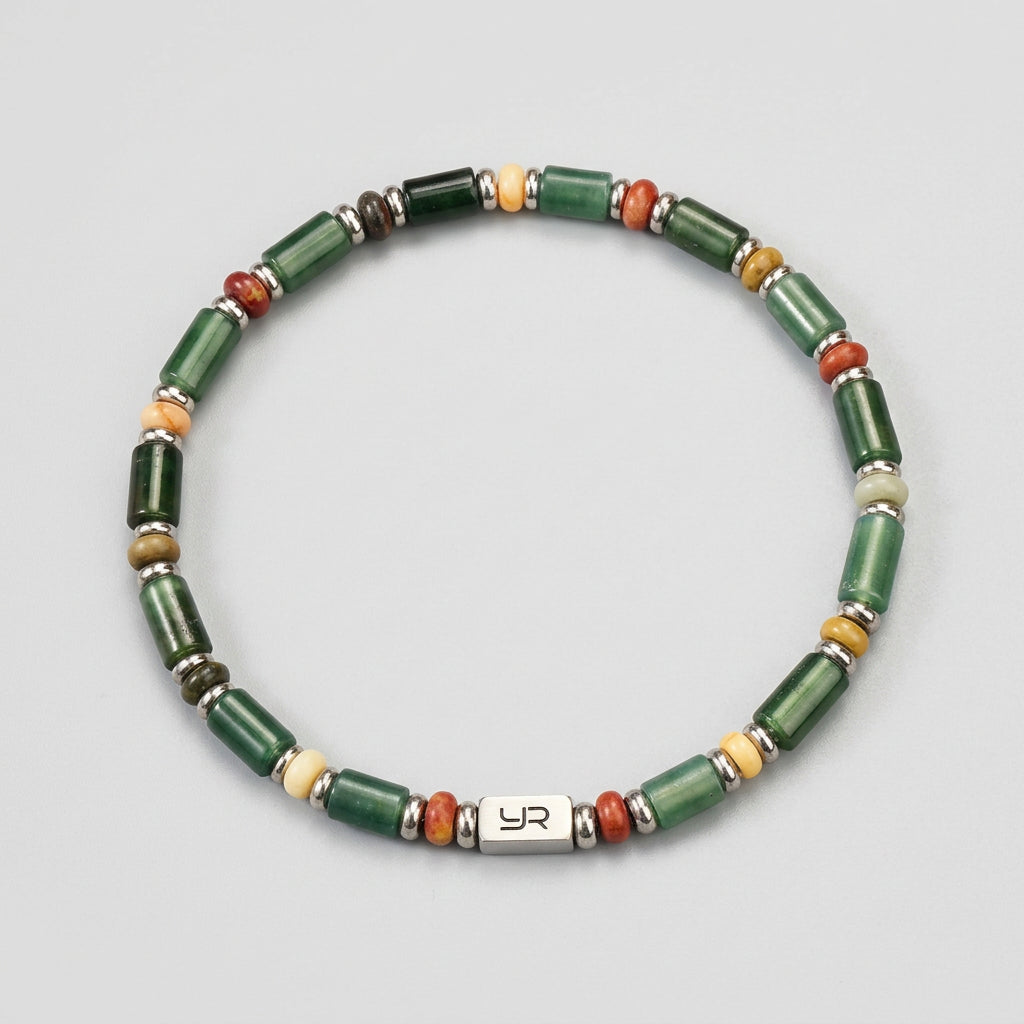 Beaded bracelet with green, red, and yellow beads on a dark stone surface