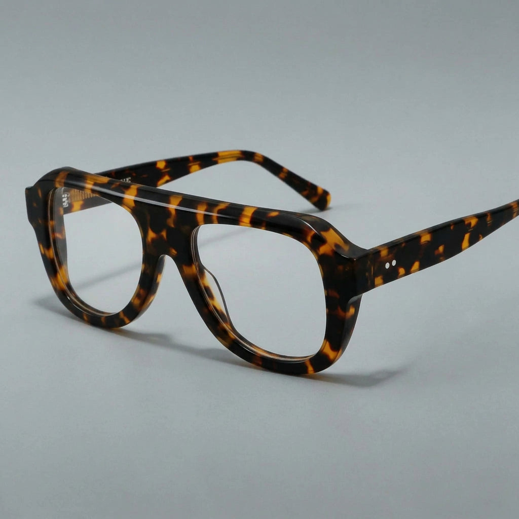 Pair of eyeglasses with a tortoiseshell frame on a gray background