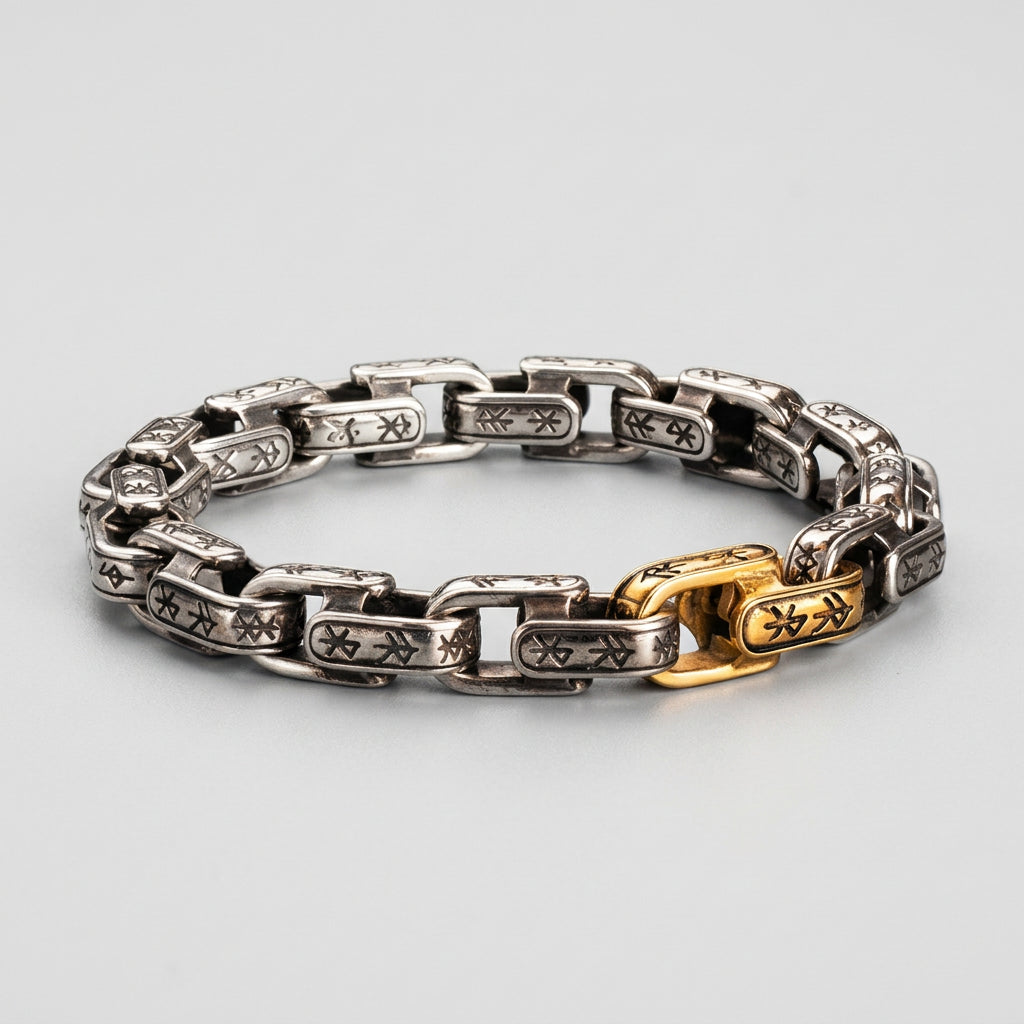 Silver and gold chain bracelet on a textured surface