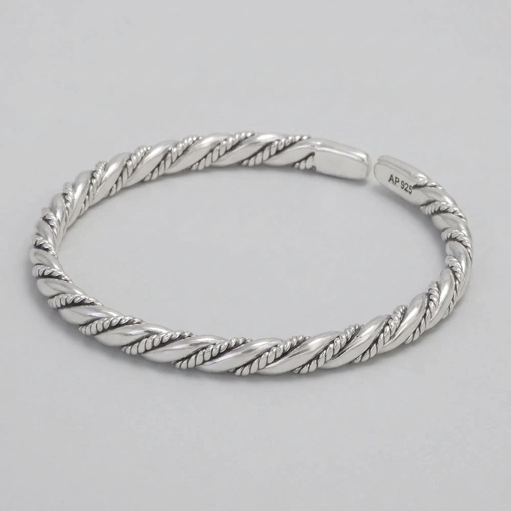 Silver braided bracelet on a dark surface