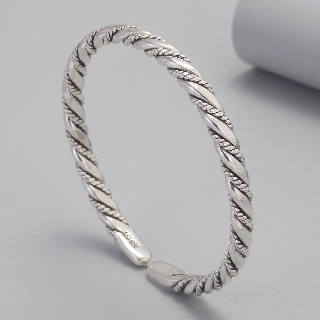 Silver braided bracelet on a dark background